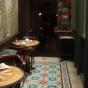Dining area with tables and chairs in a cozy restaurant setting, featuring a decorative wall with a clock and 'LYON' sign.